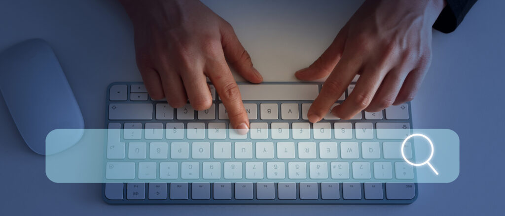 hands typing on a keyboard with a search engine display open