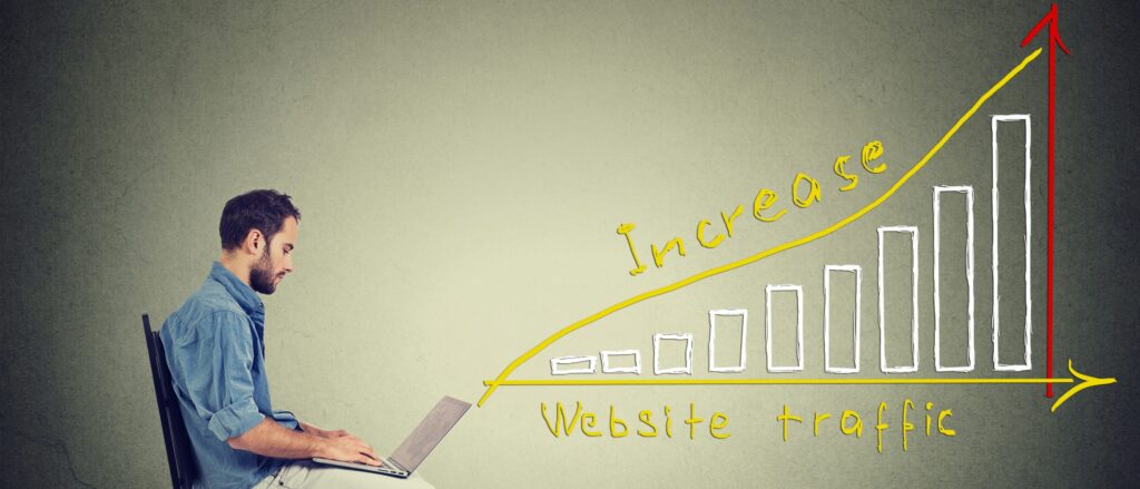 man sitting at laptop with graph depicting an increase in website traffic