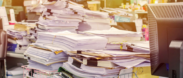 stacks and stacks of paper on office desk