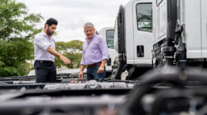 Semi truck salesperson showing trucks to a customer at the dealership