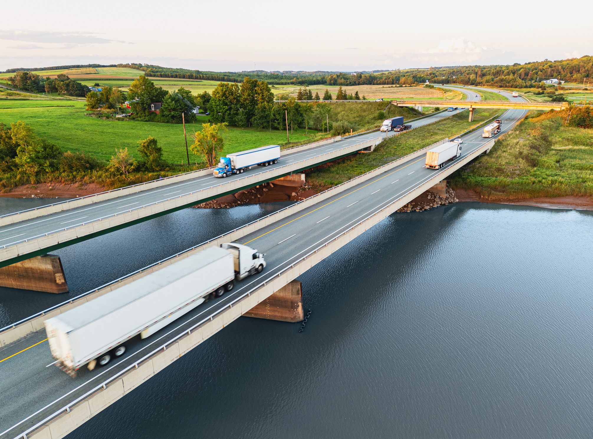Semi trucks crossing tidal river bridges.
