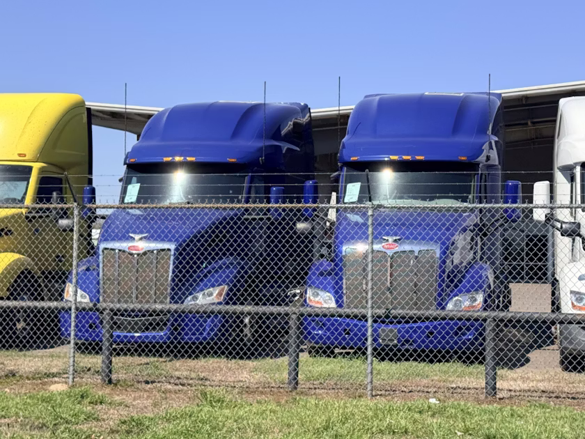 Semi Trucks parked behind a fence