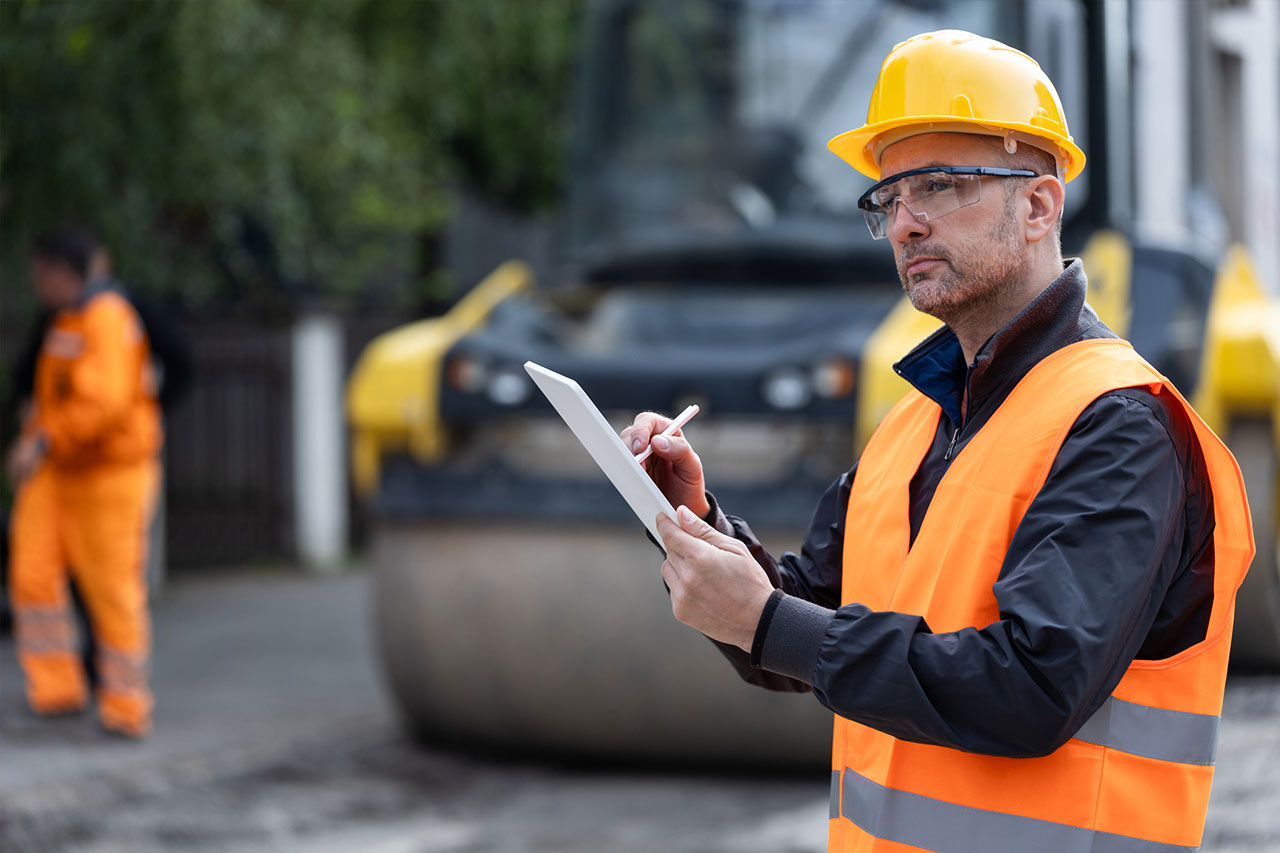 contractor with clipboard in hand while looking at equipment