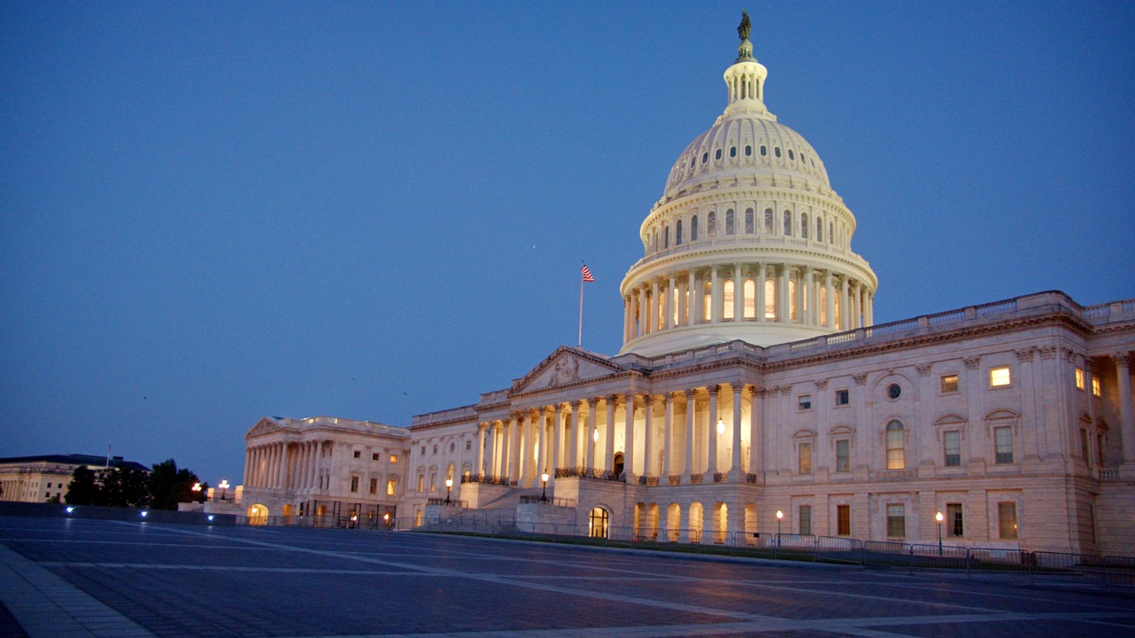 U.S. Capitol exterior at blue hour, dome lit and steps glowing, empty plaza in foreground